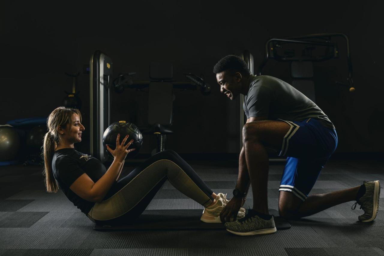 The Westin Doha Hotel & Spa Εξωτερικό φωτογραφία Personal trainer assisting a woman with a sit-up